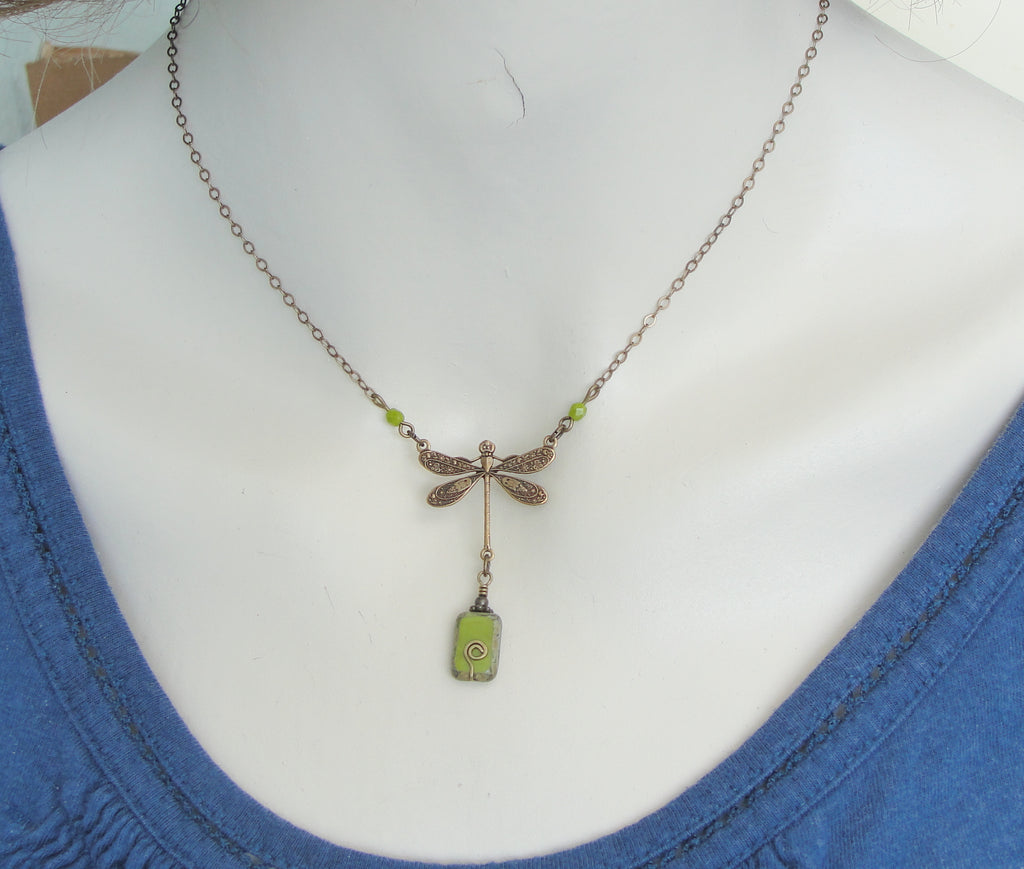 chartreuse or olive green dragonfly necklace in antiqued brass on model