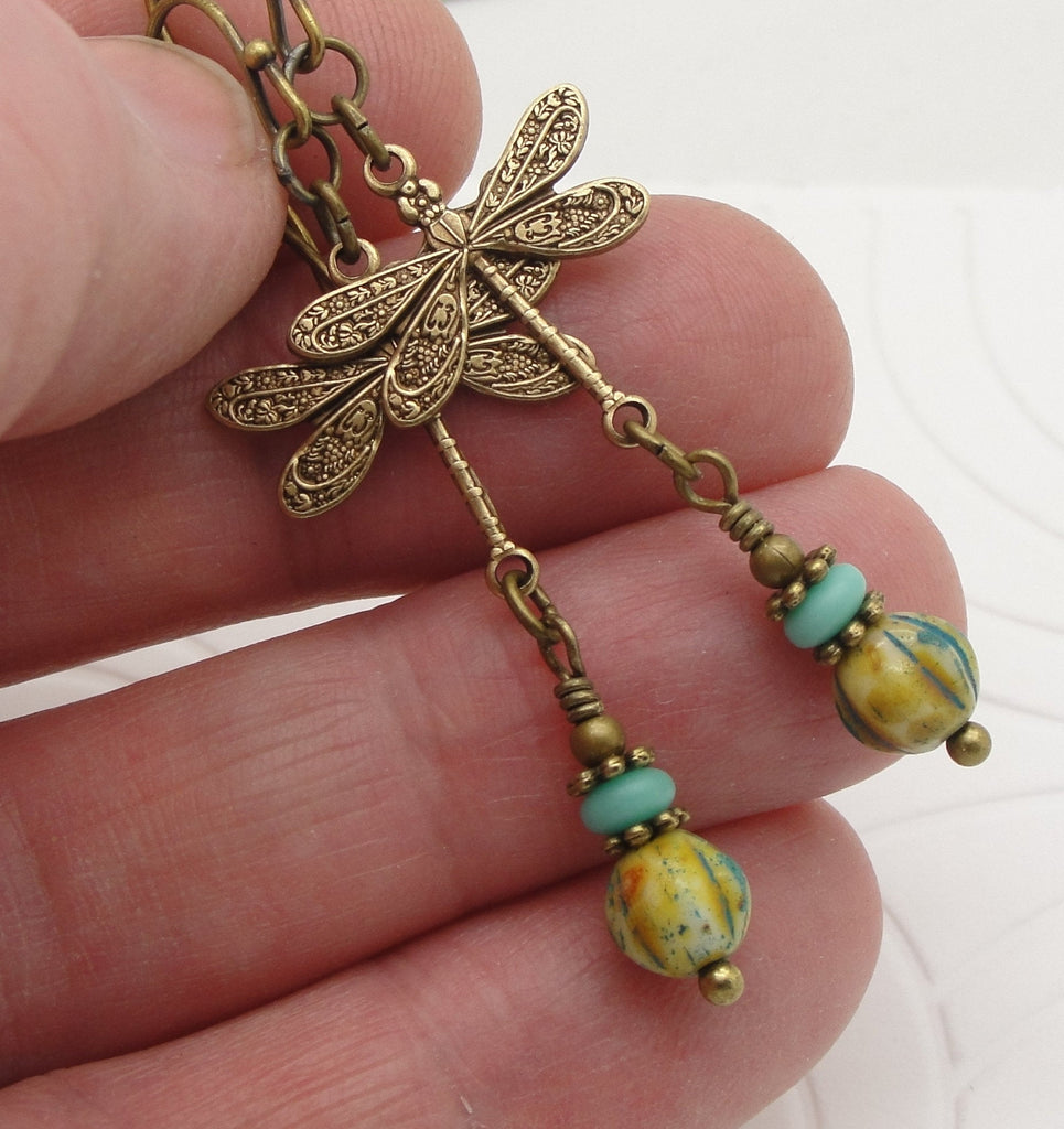 Turquoise Blue Dragonfly Earrings with Rustic and Earthy Glass Beads in Antiqued Brass pinched in fingers