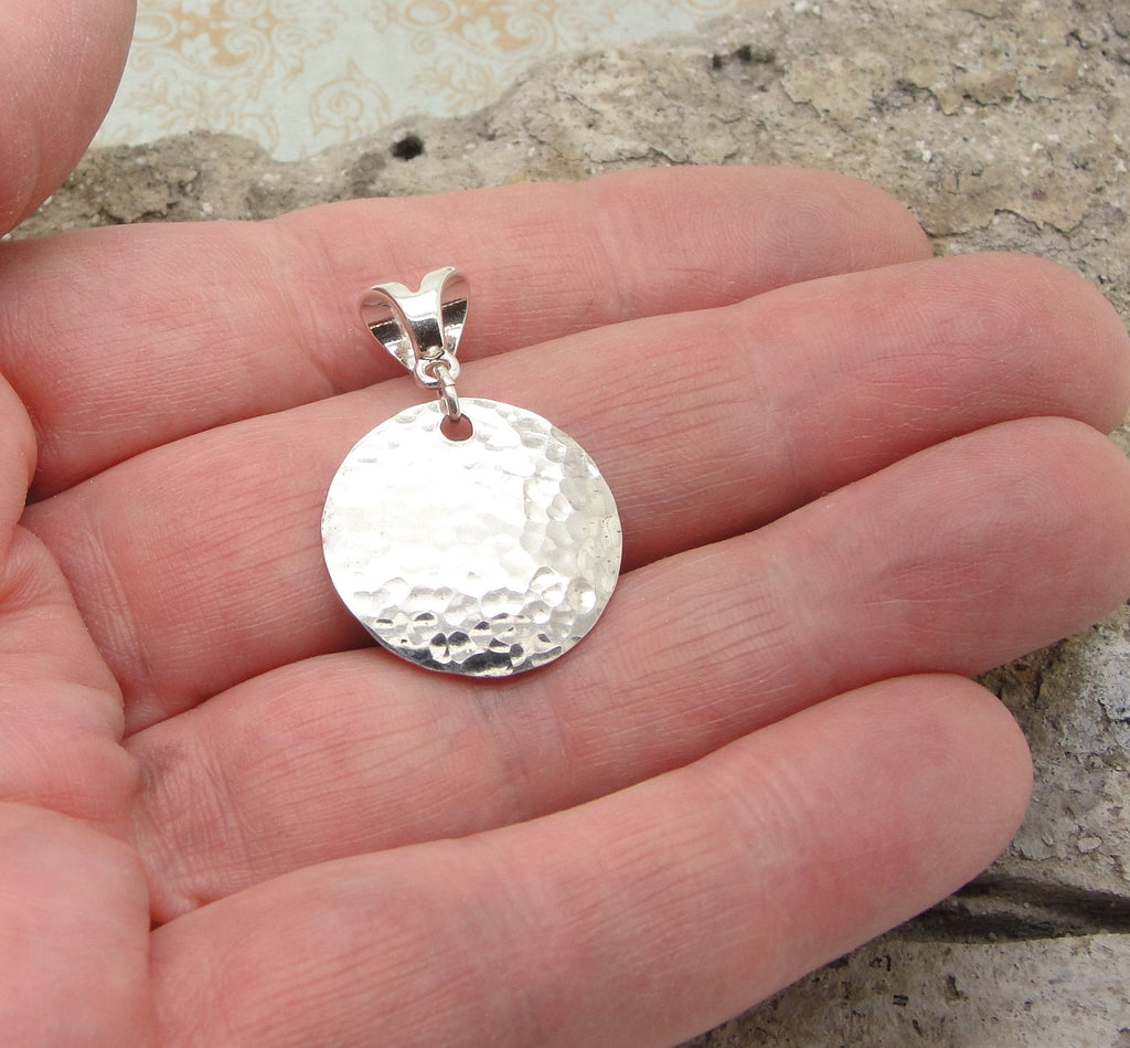 Small Hammered Disc Pendant in Sterling Silver in 3/4 Inch Diameter in hand